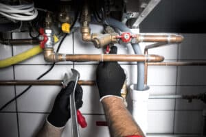 Plumber using a wrench on plumbing pipes