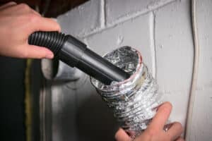 Vacuum cleaning a flexible aluminum dryer vent hose, to remove lint and prevent fire hazard.