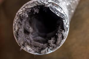 A dirty flexible aluminum dryer vent duct filled with lint, dust and dirt.
